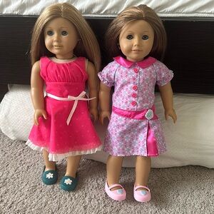 Two American Girl Dolls with clothing items.